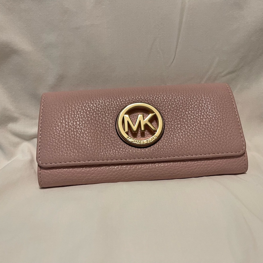 Light Pink wallet with Large Michael Kors emblem on front.